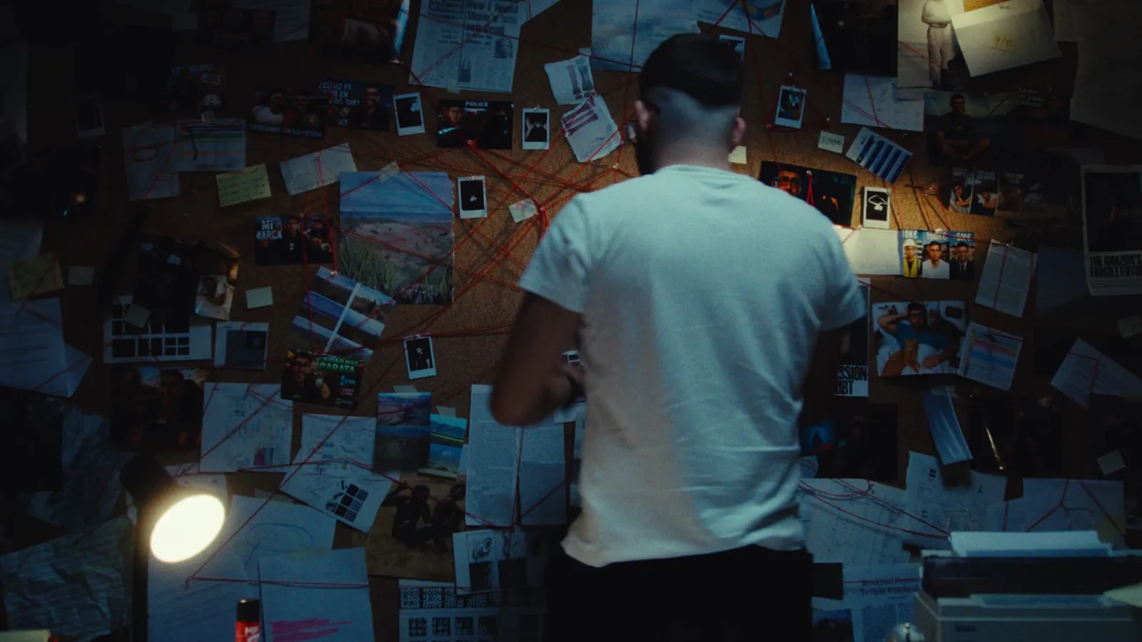 Hombre frente a un muro de pruebas en el videoclip de Jopa